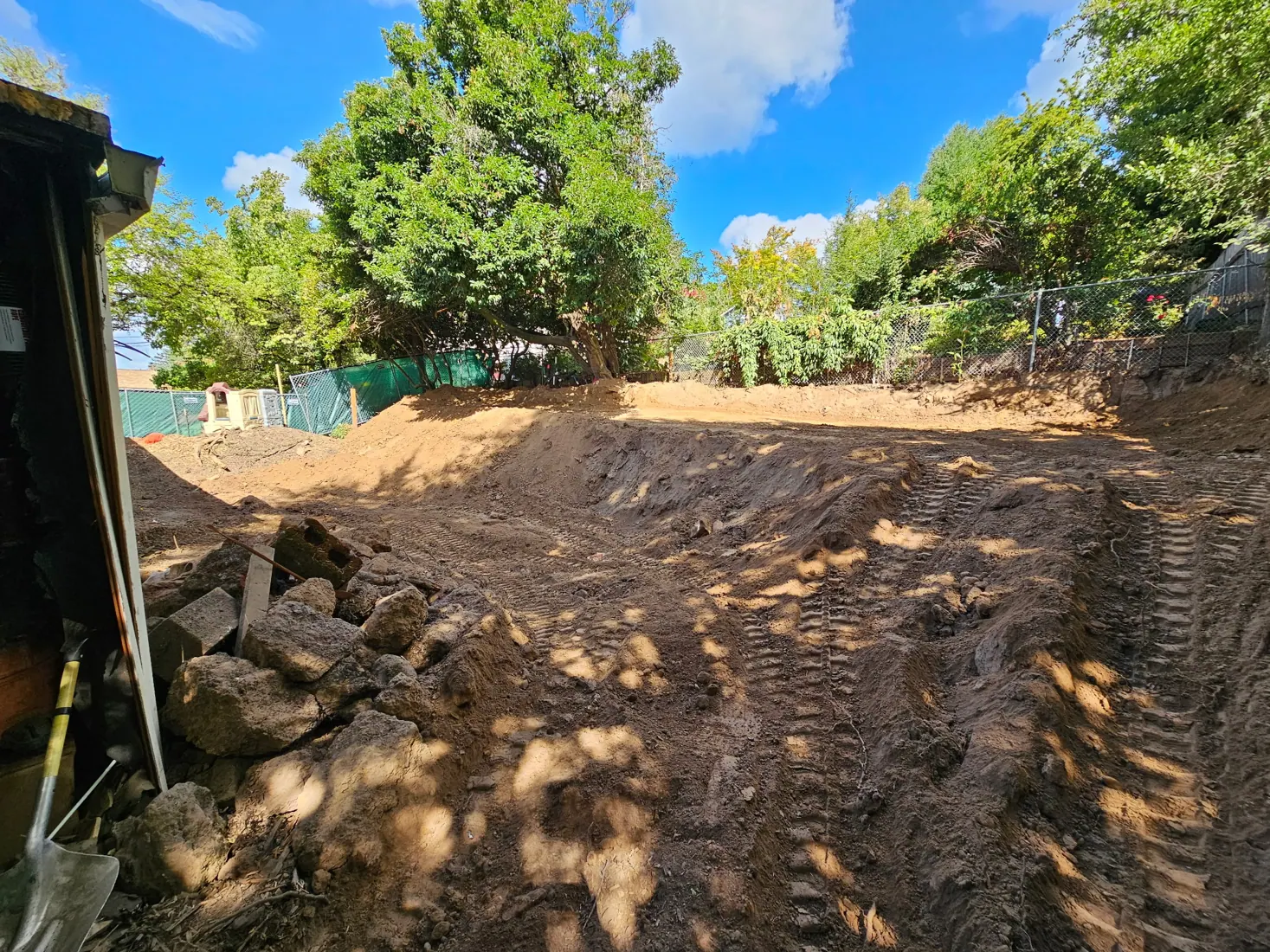 Graded earth and equipment tracks after excavation